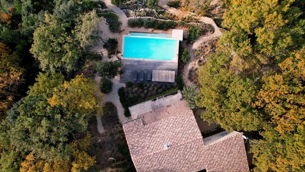 An aerial view of a property with a swimming pool, a patio area, and a tiled roof. - Farmhouse for 6 people with heated swimming pool, jacuzzi, sauna south of France (Labastide de Virac)