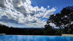 A swimming pool with a clear view of the sky and distant mountains. - Farmhouse for 6 people with heated swimming pool, jacuzzi, sauna south of France (Labastide de Virac)