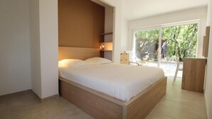 A modern bedroom with a large bed, built-in shelving, and a view of the outdoors. - Farmhouse for 6 people with heated swimming pool, jacuzzi, sauna south of France (Labastide de Virac)