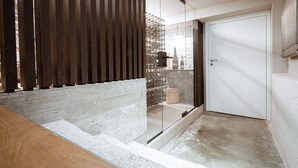 A modern staircase with a wooden handrail, a glass partition, and a white door. - Villa Rein Boutiquehotel (Bad Reichenhall)