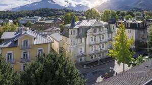 A town with historic buildings, including a prominent yellow building with balconies and a large, ornate building with a tower. - Villa Rein Boutiquehotel (Bad Reichenhall)