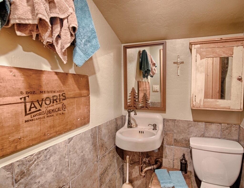 Une salle de bain avec un meuble-lavabo en bois, un évier, un miroir et des toilettes.