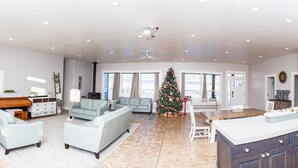 Een ruime woonkamer met een open haard, een kerstboom en een grote keuken met moderne apparatuur.