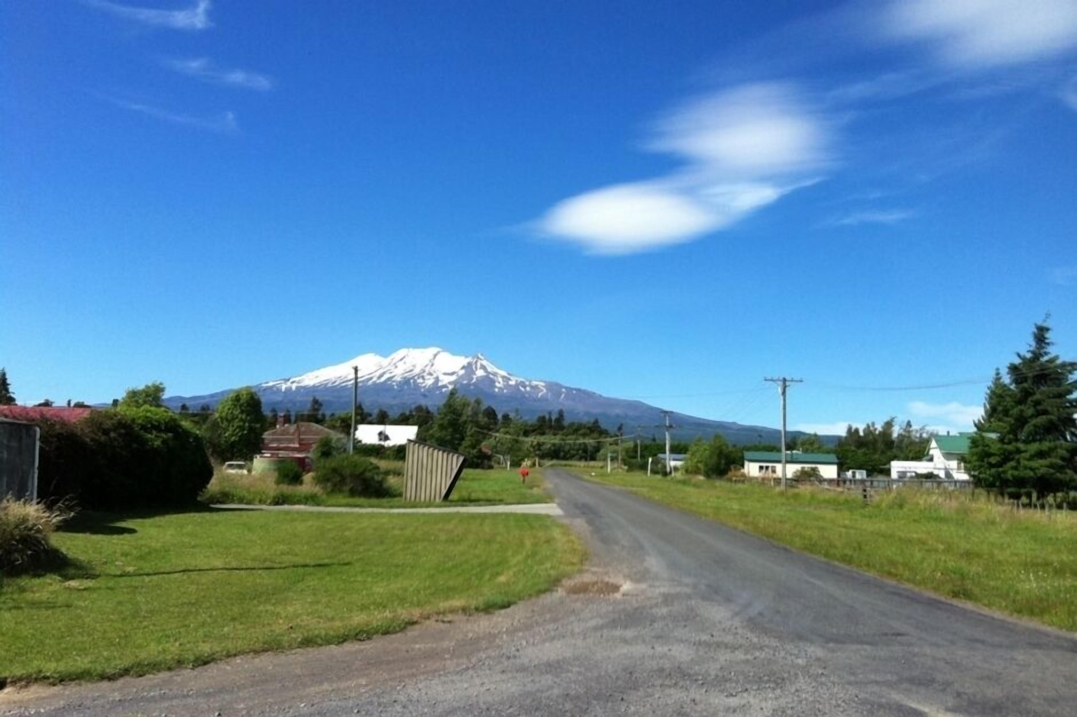 A rural road with a mountain in the background.