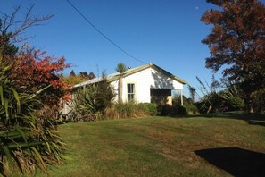 A single-story house with a gabled roof, a front garage, and a well-maintained lawn. - Ohakune ski house and summer Bach (Ohakune)