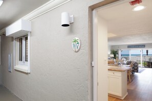 A hallway with a number sign, a window, and a door leading to a dining area with a view.
