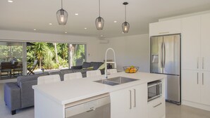 A modern kitchen with a central island, stainless steel appliances, and pendant lighting.