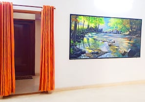 Stunning river landscape artwork adorns the wall, complemented by a neutral backdrop and elegant door.
