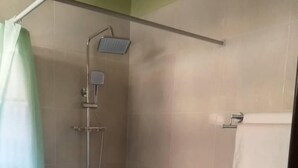 A small bathroom with a shower, toilet, and a towel rack. - Belize Motel (Kigali)