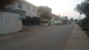 A street view with a Belize Motel sign, a paved sidewalk, and a road. - Belize Motel (Kigali)