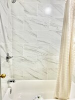 Un baño con bañera, ducha e inodoro.