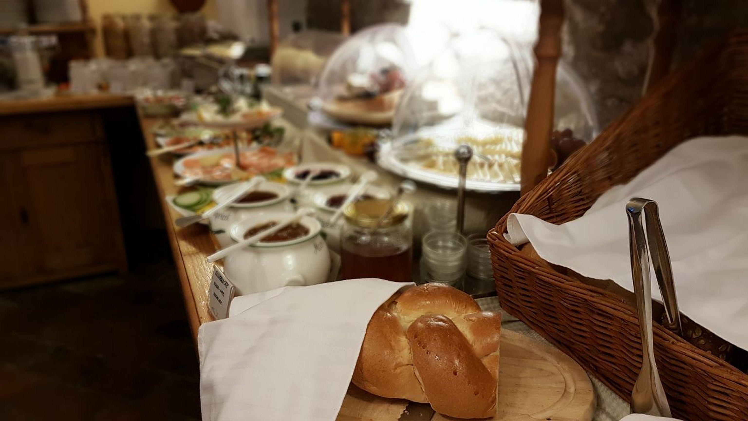 A buffet table with various dishes, including bread, sauces, and condiments.