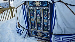 Una tenda amb dibuixos intricats blaus i blancs, envoltada de neu.