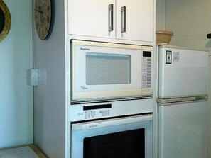 Une cuisine équipée d’un four à micro-ondes, d’un four et d’un réfrigérateur.