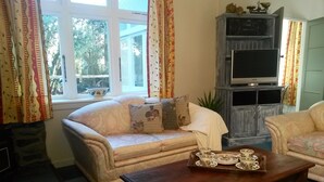Een woonkamer met een bank, een salontafel en een tv-meubel.