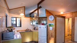 Una cocina compacta con un lavabo, un refrigerador y un ventanal.