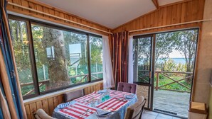 Comedor con una mesa dispuesta para dos, ventanas amplias y vistas al exterior.