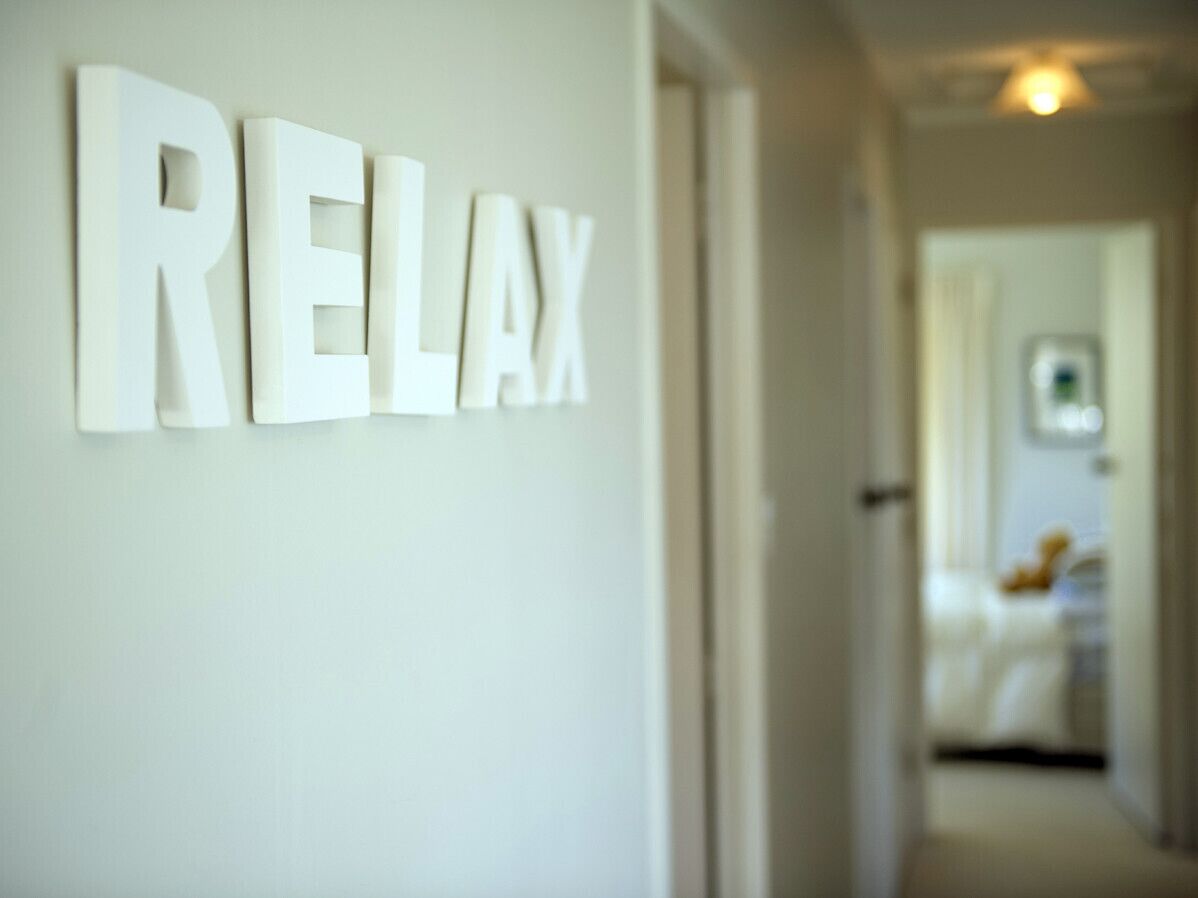 A hallway with a sign that reads "RELAX" on the wall.