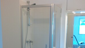 A modern bathroom with a glass-enclosed shower, a toilet, a sink, and a mirror. - Apartment bayonne T2 (Bayonne)