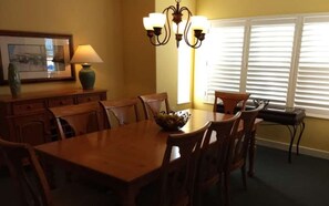 Enjoy meals in this dining area with a wooden table and six chairs, accompanied by a bowl of fresh fruit.