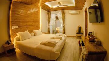 Un dormitorio con una cama grande, techo de madera y ventilador de techo.