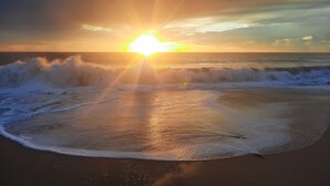 A beach with waves and the sun setting in the background. - Oceanfront Bluff Beach Retreat - Spectacular 65 Ft Swimming Pool (Isla Colon)