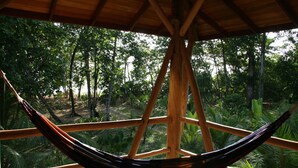 A hammock under a wooden structure with a view of a forested area. - Oceanfront Bluff Beach Retreat - Spectacular 65 Ft Swimming Pool (Isla Colon)
