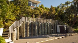 A wooden staircase leading to a building, surrounded by lush greenery. - The Ridge at Tairua - Tairua Apartment (Tairua)