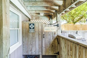 A wooden outdoor area with a pool boy sign, a directional sign pointing south, and a wooden fence.