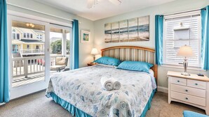 A bedroom with a large bed, a ceiling fan, a window with curtains, and a view of the outside. - Ocean Paradise | 670 ft from the Beach | Private Pool, Hot Tub | Corolla (Corolla)
