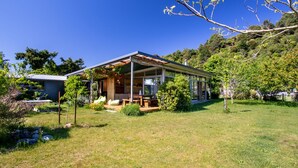 Una casa moderna con un porche cubierto, césped y jardín.