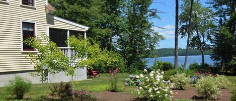 Enjoy a serene lakeside retreat with a covered porch and stunning views of the surrounding lake.