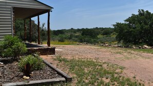 A building with a covered porch and a landscaped garden area. - Rustic Loyal Valley Private Guesthouse with Peace & Serenity Views (Mason)