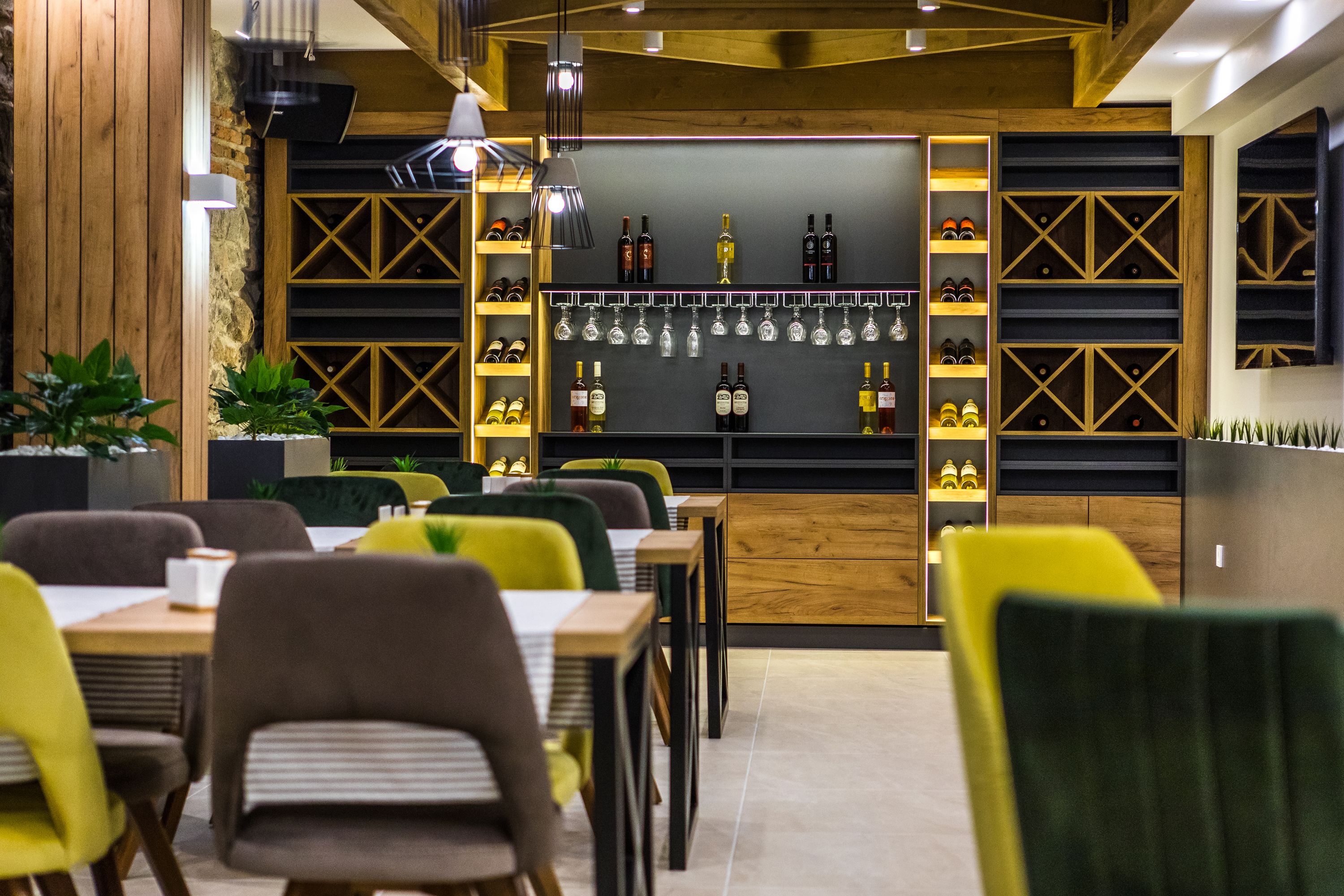 Un restaurante con paredes de madera, estantes llenos de botellas y sillas.
