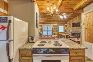 A kitchen with a stove, refrigerator, and wooden cabinets.