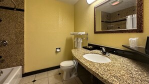 Un bagno con lavabo su piano in granito, un water, un porta asciugamani e uno specchio con cornice in legno.
