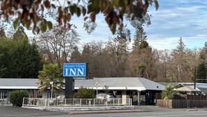 Segnaletica del Western Village Inn con un cartello di 'Nessuna camera disponibile', circondata da alberi e un parcheggio.