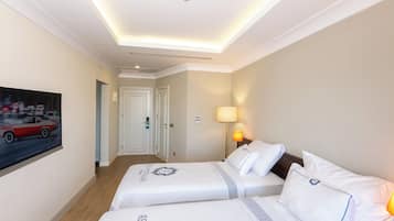 Habitación de hotel con dos camas, un cuadro en la pared, una lámpara y una luz en el techo.