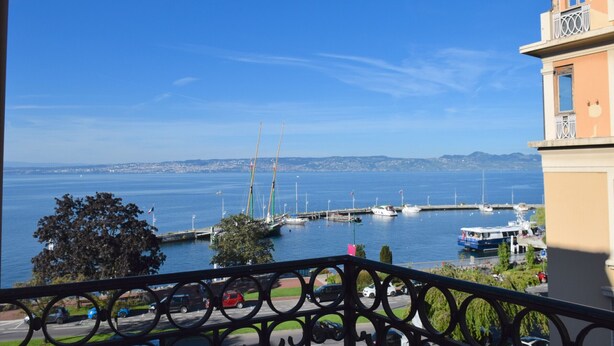 Ein Balkon mit Blick auf eine Marina, Boote und eine entfernte Skyline.