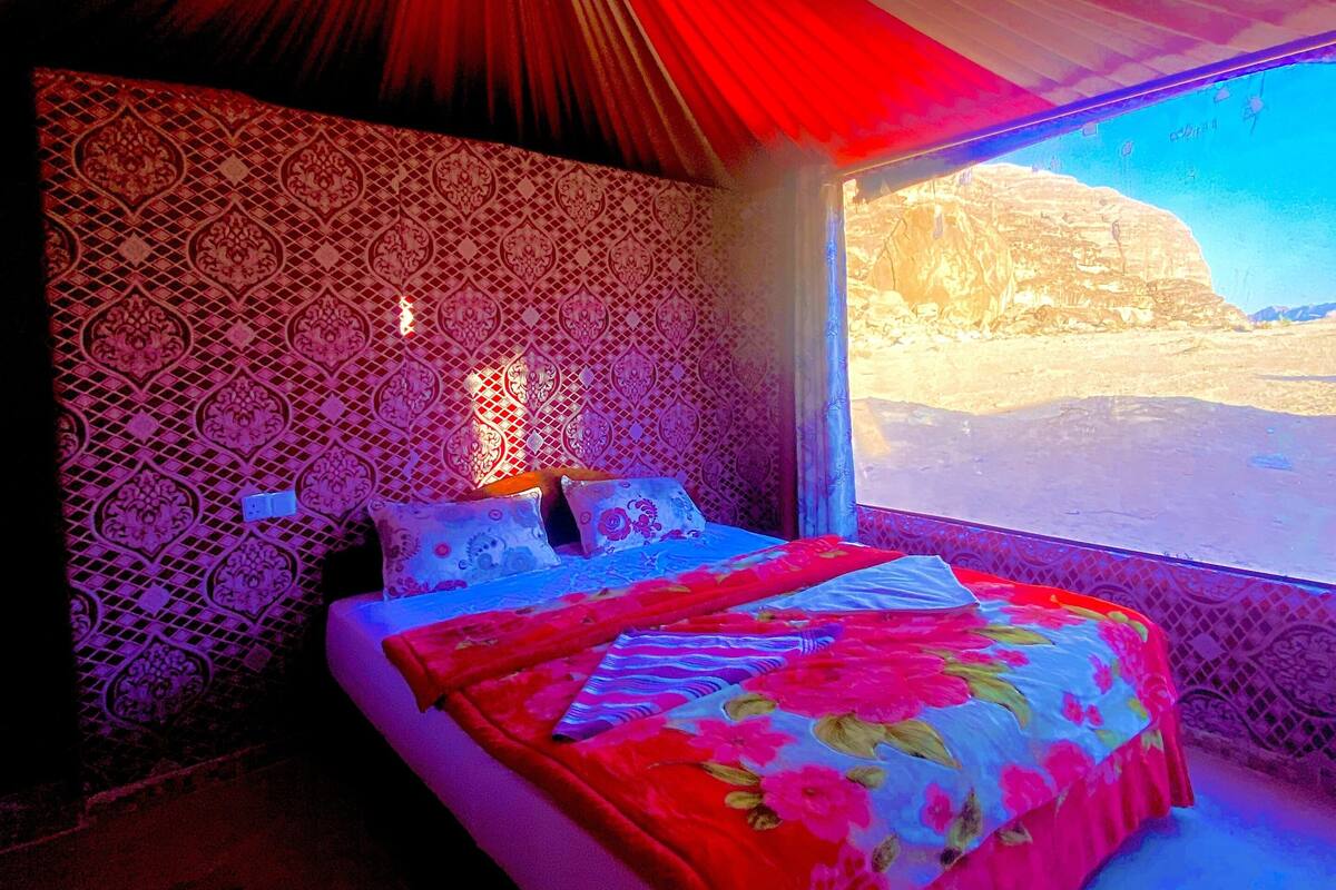 Une chambre avec un lit, des murs à motifs et une vue sur un paysage montagneux.