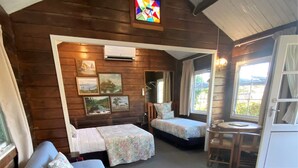 A cozy cabin with two beds, a sofa, a small table, and a window.