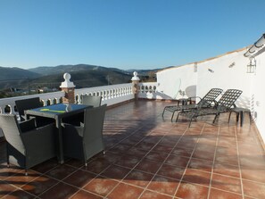 Enjoy a serene view of the distant mountains from this outdoor space with a table and chairs.