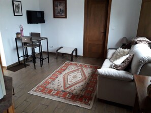 Relax in this inviting living space with a sofa, coffee table, and TV, surrounded by a geometric-patterned rug.