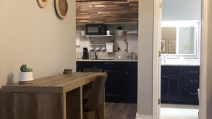 A modern kitchen with a wooden island, dark cabinets, and a patterned rug. - Casa Indigo -- Cozy & Chic in GREAT LOCATION! (San Antonio)