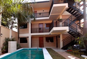 Ein mehrstöckiges Gebäude mit Swimmingpool, Balkonen und einer Treppe.