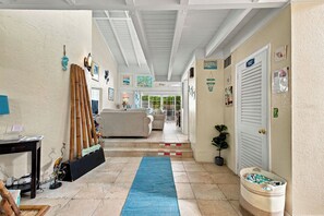 A hallway with a blue carpet, a reception desk, a sofa, and a door labeled 'Laundry Room'.