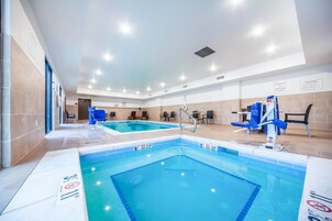 Una piscina interior con agua cristalina, líneas de profundidad marcadas y equipo de socorristas.