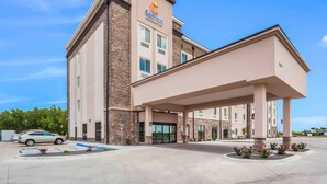A Comfort Inn hotel with a modern design, featuring a covered entrance and a parking area.