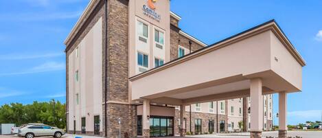 Un hotel Comfort Inn con diseño moderno, que cuenta con una entrada cubierta y un estacionamiento.