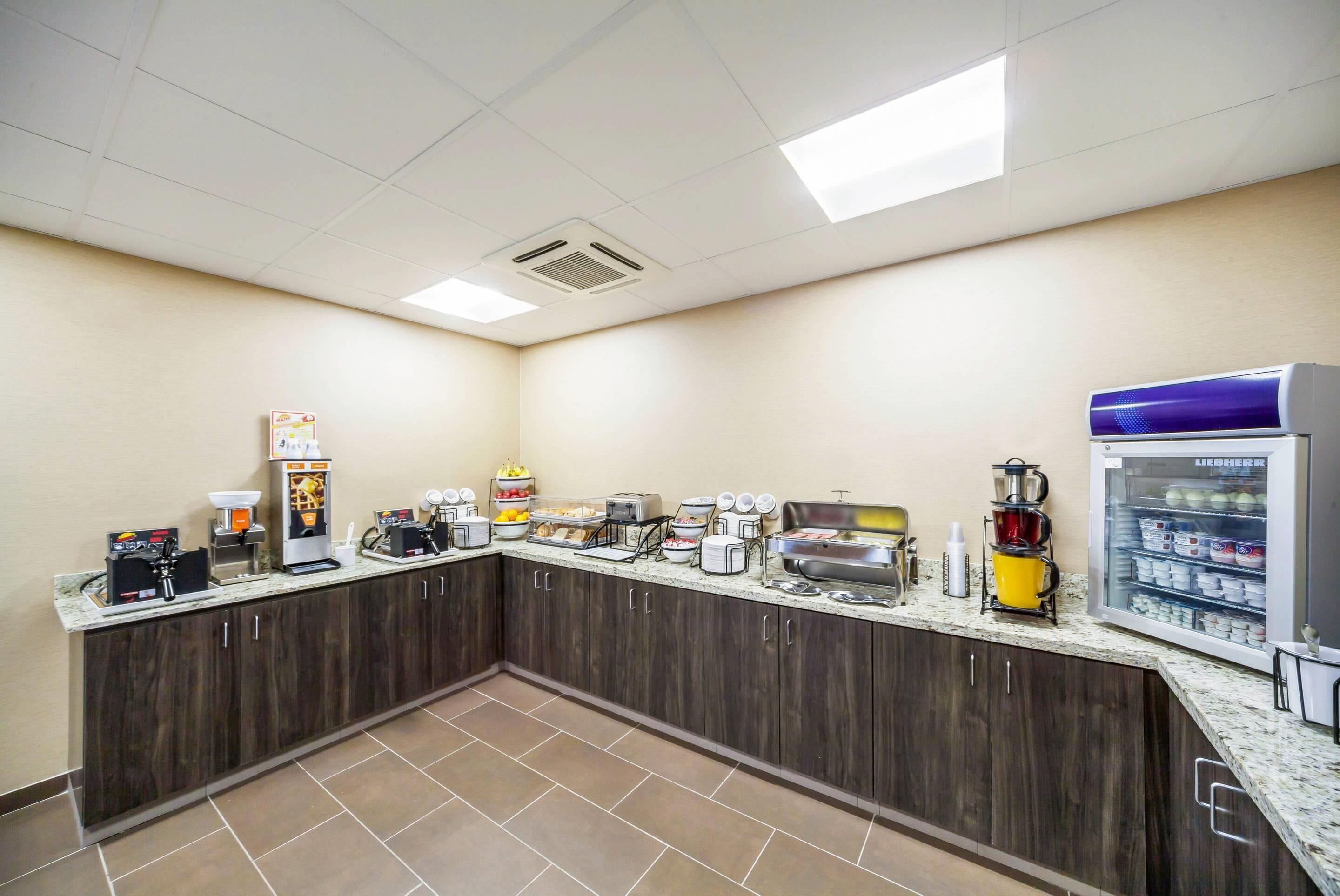 A self-service breakfast area with a coffee machine, toaster, and refrigerator.